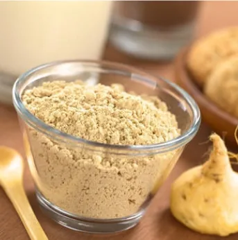 Maca powder in a glass bowl beside whole maca roots, brand image shown for the maca page